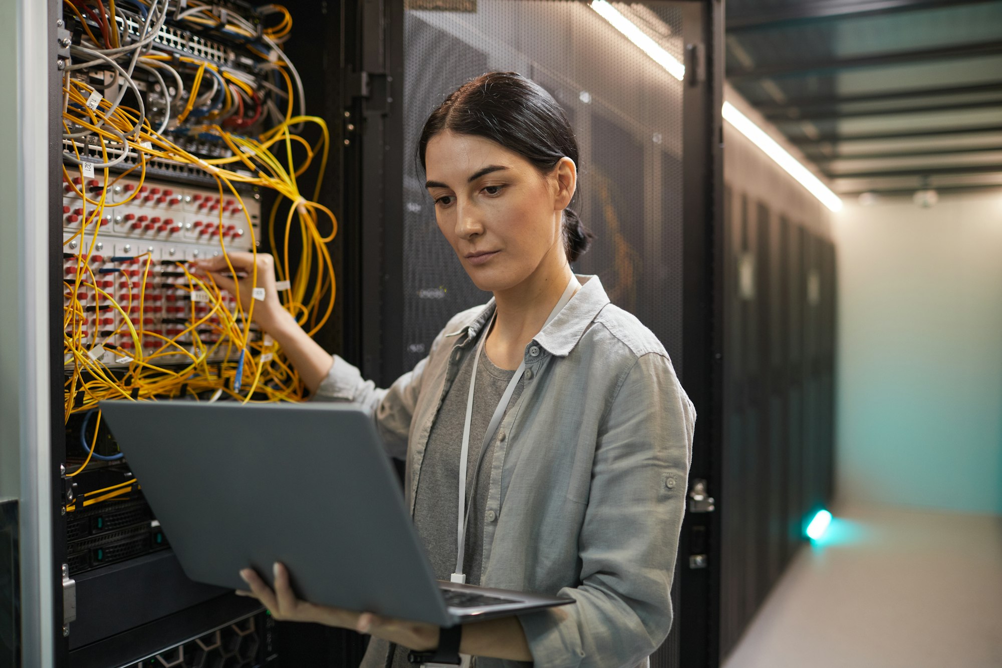 Female Network Technician Inspecting Servers in Data Center Female Network Technician Inspecting Servers in Data Center