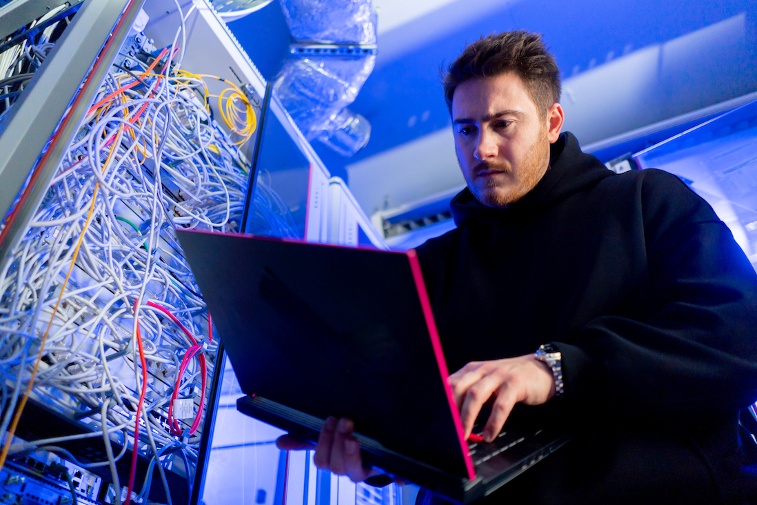 focused hacker in data center hacking software system vulnerable cyber security server room technology digital world metaverse